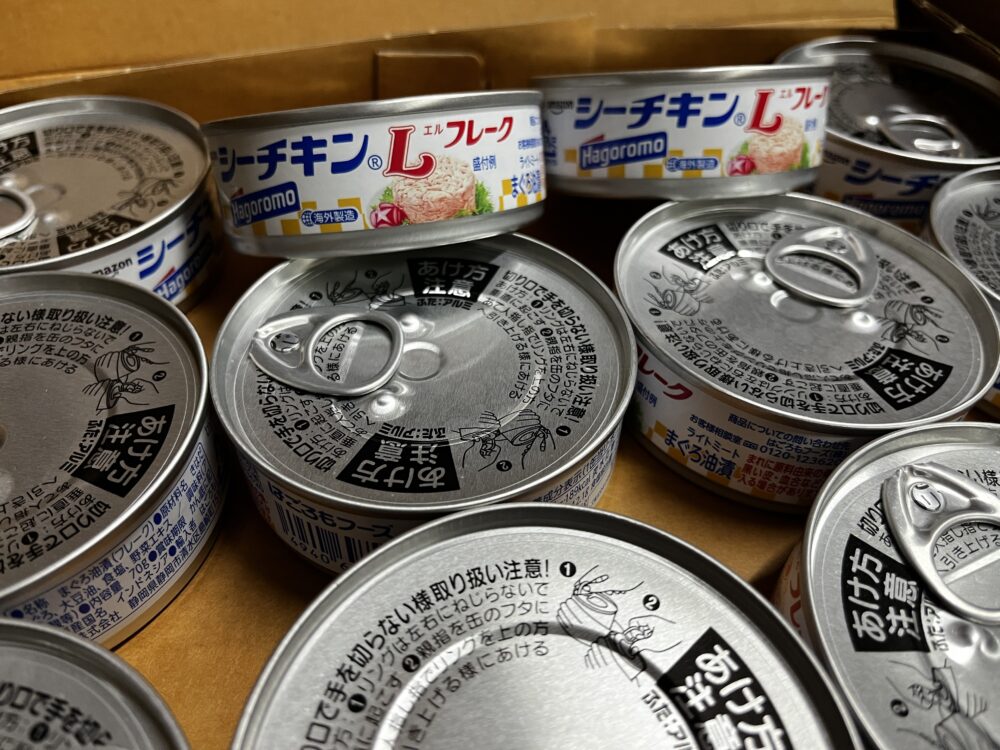 段ボール箱の中に並んだシーチキンの缶