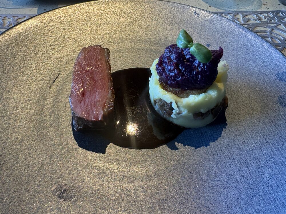 Nocturne Okinawaの肉料理。ロゼ色に焼かれた肉と、紫色の付け合わせを乗せたマッシュ